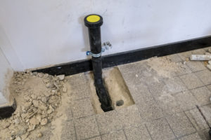 a black polypropylene drain pipe worked into the floor