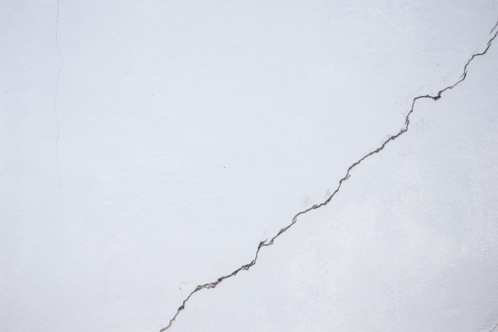 Cracked line on white building wall